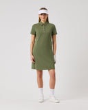 Woman wearing a green dress and white visor on a light gray background