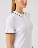 Woman wearing a white polo shirt with blue accents on a light gray background