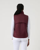 Person wearing a maroon vest on a white background