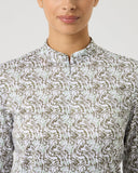Person wearing a patterned shirt against a plain background