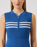 Woman wearing a blue sleeveless ribbed top with white stripes on a light gray background