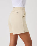 Beige shorts worn by a person on a plain background