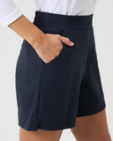 Person wearing navy shorts on a plain background