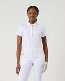 Woman wearing a white polo shirt and pants on a plain background