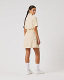 Person wearing a beige dress on a white background