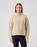 Woman wearing a beige fleece jacket on a light gray background