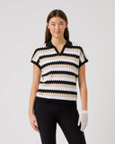 Woman wearing a black and white striped polo shirt on a plain background