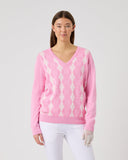Woman wearing a pink sweater with a white pattern on a light gray background