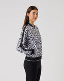 Woman wearing a black and white patterned jacket on a gray background