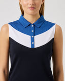 Woman wearing a sleeveless dress with a blue and white collar on a plain background