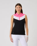 Woman wearing a black and pink sleeveless top with white pants on a gray background