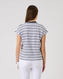 Woman wearing a black and white striped shirt and white pants on a plain background