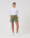 Woman wearing a white shirt and green shorts on a plain background