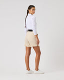Woman wearing a white long-sleeve shirt and beige shorts on a white background