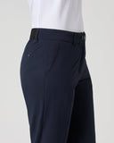Navy pants worn with a white shirt on a light gray background