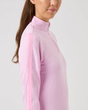 Woman wearing a light pink blouse with a subtle pattern on a plain background