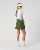 Daily Sports Woven Khakora in green  – women's A-line woven golf skort showing back kick pleat, structured waistband and clean tailored fit, three-quarter back view on model styled with white 3/4 sleeve polo and white visor