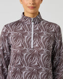 Close-up of women's zebra print half zip golf top with stand-up collar, silver zipper pull, and allover wave print detail
