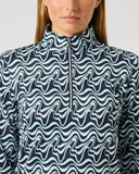 Close-up of women's navy and white wave print half zip golf top with stand-up collar and silver branded zipper pull
