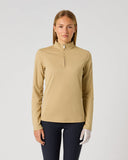 A woman modeling a beige long-sleeve quarter-zip athletic pullover against a plain light gray studio background.