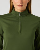 A woman wearing a dark olive green long-sleeve quarter-zip pullover top, shown from the chest up against a light gray studio background.