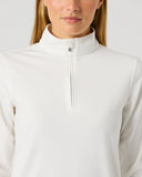 A woman wearing a white long-sleeve quarter-zip pullover with a mock neck collar, shown from the chest up against a light gray studio background.