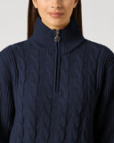 Daily Sports Dark Navy Cable Pullover Unlined close-up of deep navy cable-knit pattern with quarter-zip ribbed stand collar and gold logo zipper pull detail