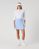 Daily Sports Light Blue Ribbed Skort in powder blue – women's smooth A-line golf skort with elasticated waistband and built-in shorts, full length front view on model styled with white long sleeve polo and viso