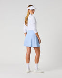 Daily Sports Light Blue Ribbed Skort in powder blue – women's smooth A-line golf skort showing clean back panel and flared hem, three-quarter back view on model styled with white long sleeve polo and viso