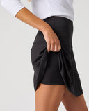 Daily Sports Black Ribbed Skort close-up of black tonal ribbed fabric with high elasticated waistband and built-in shorts visible at lifted hem, side detail view