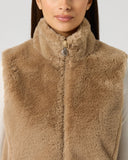 Close-up of women's camel faux fur golf vest with high stand-up collar, two-way zip, and Daily Sports branded zipper pull
