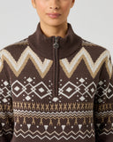 Close-up of women's brown jacquard golf pullover with zigzag and diamond Fair Isle pattern, ribbed collar, and Daily Sports branded zipper pull
