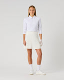 Daily Sports Madelene White Cable Knit Skort in cream ivory – women's cable-knit pleated golf skort with elasticated waistband and built-in shorts, full length front view on model styled with light blue polo