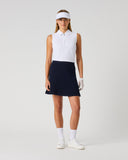 Daily Sports Madelene Dark Navy Cable Knit Skort in deep navy – women's cable-knit pleated golf skort with elasticated waistband and built-in shorts, full length front view on model styled with white sleeveless polo and viso