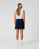 Daily Sports Madelene Dark Navy Cable Knit Skort in deep navy – women's cable-knit pleated golf skort showing flared pleated hem and clean back panel, full length back view on model styled with white sleeveless polo and visor