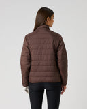 A woman viewed from the back wearing a dark brown quilted puffer jacket and black pants, standing against a plain light gray studio background.