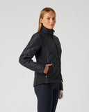 A woman modeling a black quilted athletic jacket with a high collar and front zipper, paired with dark leggings, against a plain light gray studio background.