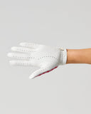 A white leather golf glove worn on a person's hand, shown in profile against a solid light gray background.