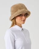Daily Sports Fur Bark Hat in warm camel bark – women's faux fur bucket hat with structured brim, side view styled with white golf polo