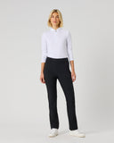 A woman modeling a white long-sleeve polo shirt and black trousers against a light gray studio background.