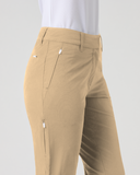 A side view of a person wearing beige zippered golf pants with a white shirt, shown against a light gray studio background.