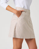 Daily Sports Stripe Bark Skort close-up of warm camel and white vertical stripe fabric with tailored waistband, angled side pocket and front pleat detail, side view