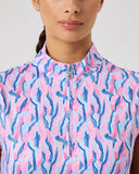 Woman wearing a sleeveless shirt with a pink and blue pattern on a plain background