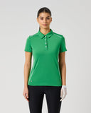 Daily Sports Leaf Piping Short Sleeve Polo in green – women's short sleeve golf polo with white contrast piping along shoulders and side seams, classic collar and white button placket, front view on model styled with navy trousers and golf glove
