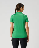 Daily Sports Dark Leaf Piping Short Sleeve Polo in green – women's short sleeve golf polo showing white contrast piping along shoulder seams and clean tailored back panel, back view on model styled with navy trousers and golf glove