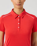 A woman wearing a bright red short-sleeve polo shirt with white contrast piping along the shoulders and sides, shown against a light gray studio background.