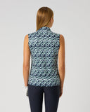 A woman viewed from the back wearing a sleeveless high-neck top with a blue, white, and gray wavy geometric pattern, paired with dark leggings, against a light gray studio background.