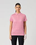 A woman modeling a short-sleeve collared polo shirt with a pink and white gingham check pattern, paired with black pants and a white glove, against a light gray studio background.