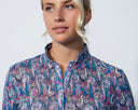 Woman wearing a patterned shirt against a plain background
