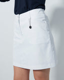 White skirt worn by a person on a plain background